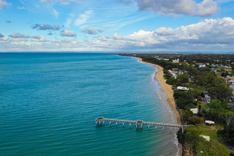 Picture showing an aerial view of Hervey Bay featuring Scarness Jetty and Scarness Beach.