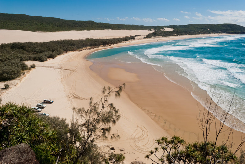 Picture showing the beach at the world's largest sand island, K'Gari (Fraser Island) with pristine waters and golden sand. 