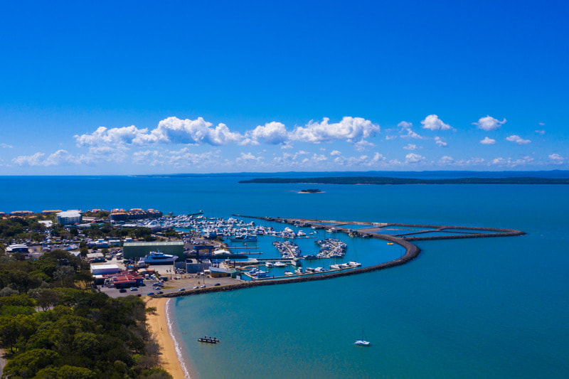 Picture of Hervey Bay marina at Urangan showing an aerial view of the boats in the harbour, the ocean and Fraser Island. 