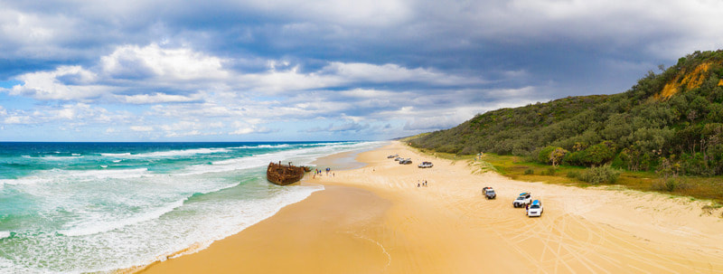 Picture showing the Maheno on Fraser Island, located on the Fraser Coast near Pinnacle estate in Hervey Bay. The image shows a ship wreck, golden sand, an island and the azure ocean. 