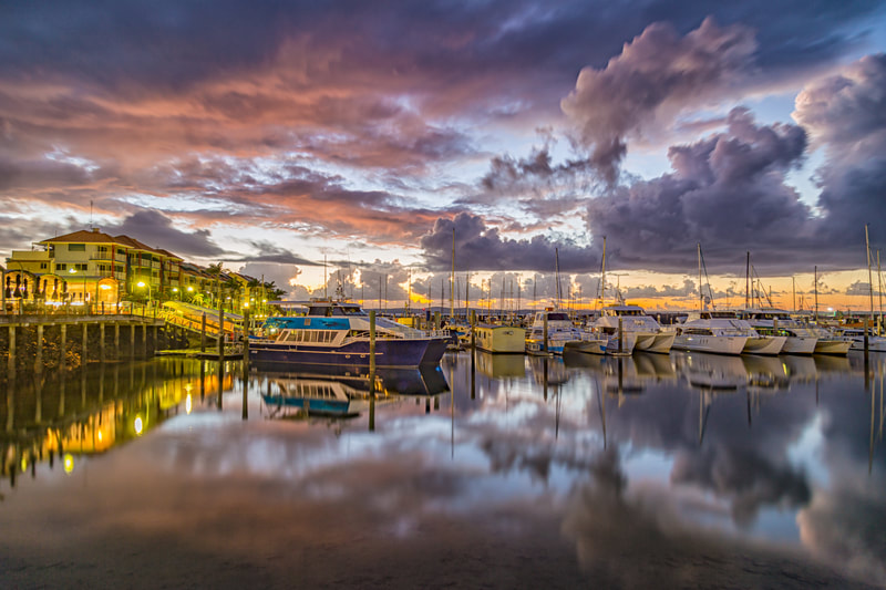 Picture of sunset at Urangan boat harbour. The water is calm and the clouds and lights are reflecting off the water looking beautiful.